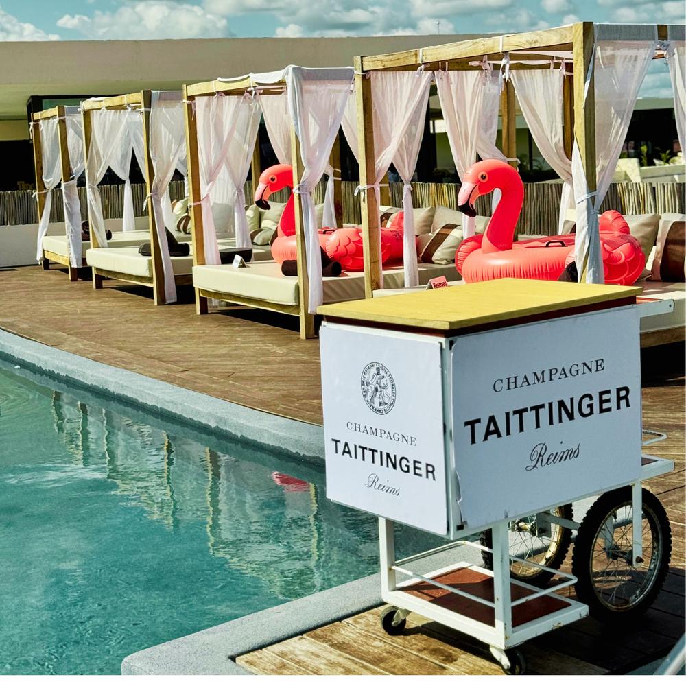 Poolside cabanas and a champagne cart set up for a wedding welcome party