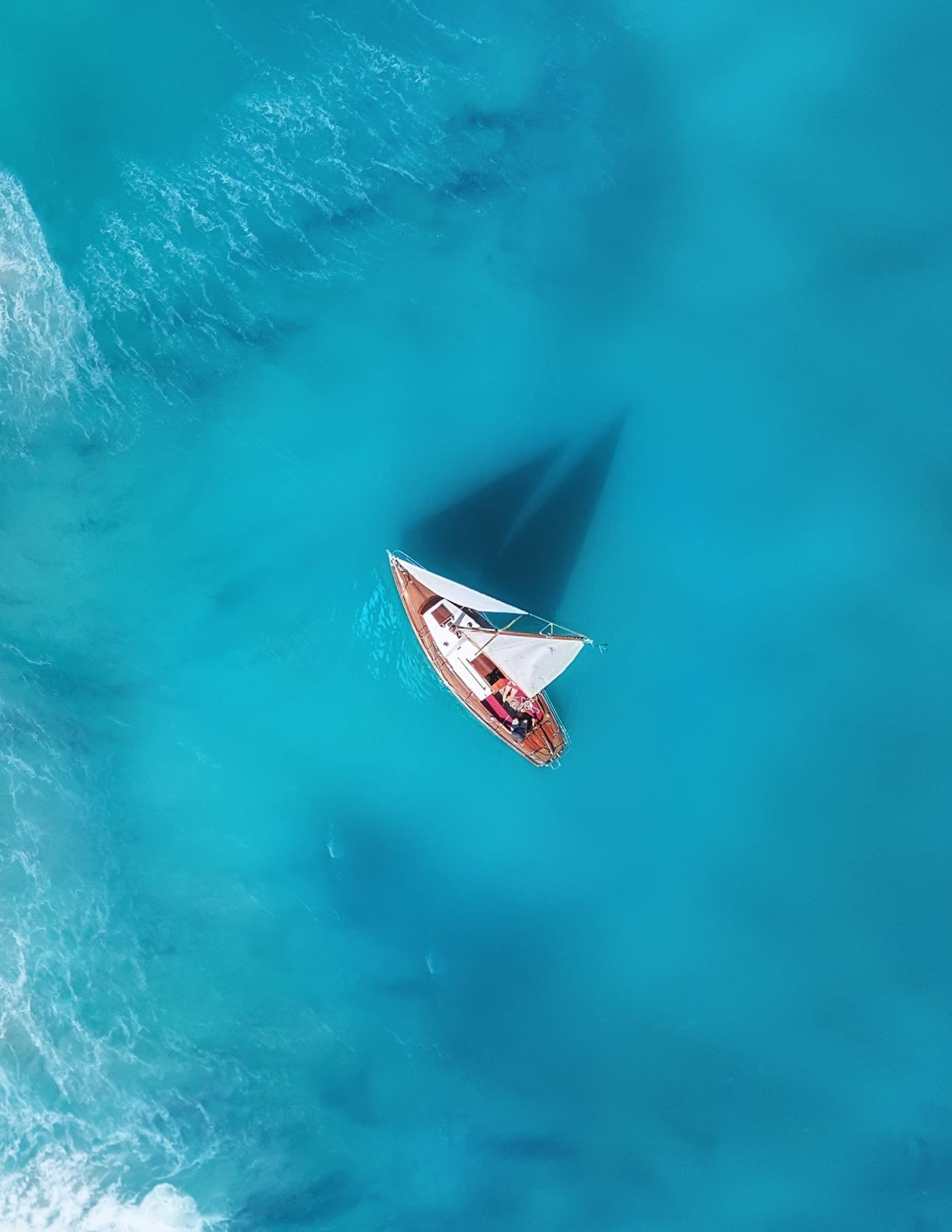 Aerial view of a sailboat in turquoise Caribbean waters